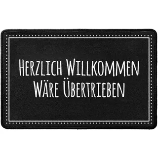 Pechkeks Fußmatte mit Spruch „Herzlich Willkommen wäre übertrieben. “ (67 x 43cm; rutschfest, waschbar, schwarz)